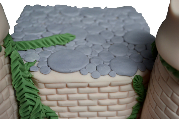 castle cake made of vanilla and fondant decorated with fondant rocks, fondant bricks, fondant castle perfect for a queen castle or king castle by sugar street boutique toronto