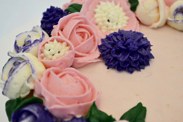 icing flower cake by sugar street boutique. sugar street boutique. icing flower cake. icing flower cake toronto. toronto cakes. lemon cake. lemon curd filling. lemon cream cheese icing. lemon flowers. cream cheese flowers. flowers cake. flowers cake toronto. designer cake. purple flowers cake.  colourful flower cake. light pink flowers icing. pink and purple icing flowers. piping flowers.  icing flowers cake toronto.