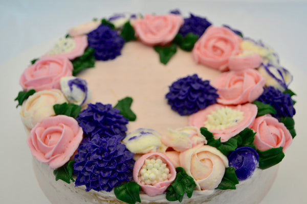 icing flower cake by sugar street boutique. sugar street boutique. icing flower cake. icing flower cake toronto. toronto cakes. lemon cake. lemon curd filling. lemon cream cheese icing. lemon flowers. cream cheese flowers. flowers cake. flowers cake toronto. designer cake. purple flowers cake.  colourful flower cake. light pink flowers icing. pink and purple icing flowers. piping flowers.  icing flowers cake toronto.