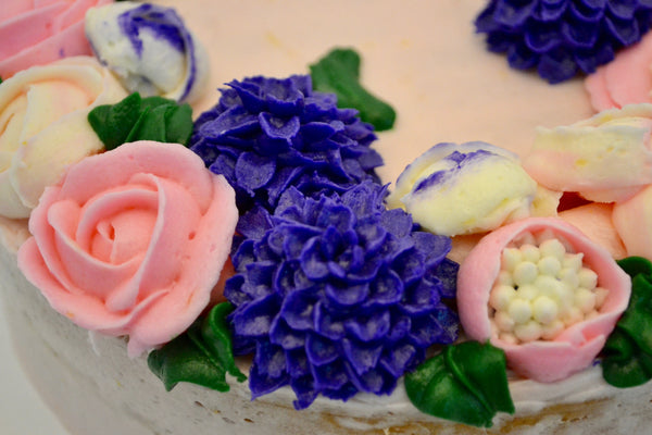 icing flower cake by sugar street boutique. sugar street boutique. icing flower cake. icing flower cake toronto. toronto cakes. lemon cake. lemon curd filling. lemon cream cheese icing. lemon flowers. cream cheese flowers. flowers cake. flowers cake toronto. designer cake. purple flowers cake.  colourful flower cake. light pink flowers icing. pink and purple icing flowers. piping flowers.  icing flowers cake toronto.