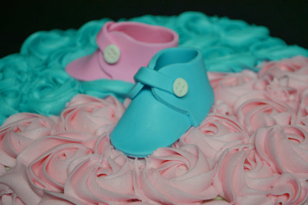 Vanilla Gender reveal baby cake with pink and blue rosettes and pink or blue smarties in the centre to reveal the gender of the baby by Sugar Street Boutique Toronto.