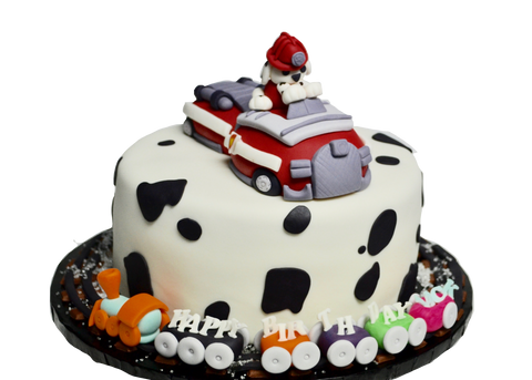 Marshall Paw Patrol cake with Fire truck and train on train cakes around the cake and dog prints with edible decorations and covered in fondant by Sugar Street Boutique