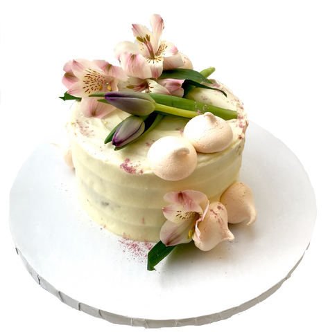 4 layer lemon cake with lemon curd in between layers and iced with a light lemon icing. Decorated with meringues, lillies & tulips by sugar street boutique toronto.
