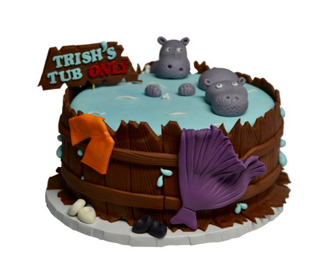 Hippos in a hot tub cake with clothes hanging over the tub decorated with fondant and water spilling over the tub by sugar street boutique toronto
