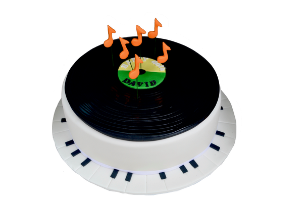 Vinyl record cake with orange musical notes and an edible piano as the cake plate. Carrot cake. Sugar street boutique. Toronto cakes