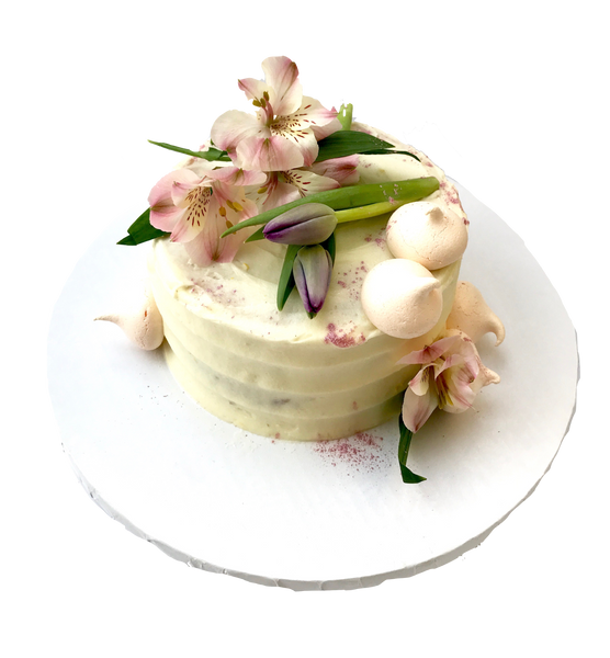 4 layer lemon cake with lemon curd in between layers and iced with a light lemon icing. Decorated with meringues, lillies & tulips by sugar street boutique toronto.