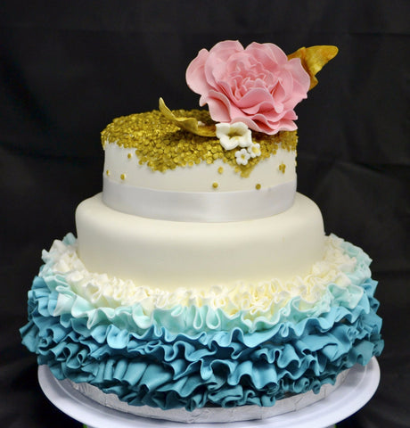 3 TIER WEDDING CAKE WITH BLUE OMBRE RUFFLES AND GOLD SEQUIN WITH A PINK FLOWER ON TOP BY SUGAR STREET BOUTIQUE TORONTO.