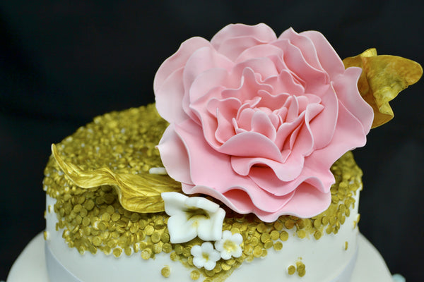 3 TIER WEDDING CAKE WITH BLUE OMBRE RUFFLES AND GOLD SEQUIN WITH A PINK FLOWER ON TOP BY SUGAR STREET BOUTIQUE TORONTO.