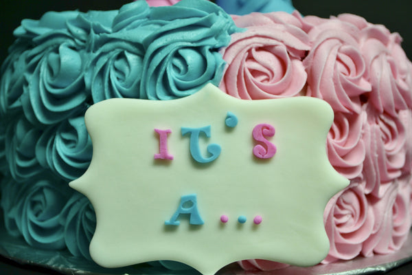 Vanilla Gender reveal baby cake with pink and blue rosettes and pink or blue smarties in the centre to reveal the gender of the baby by Sugar Street Boutique Toronto.