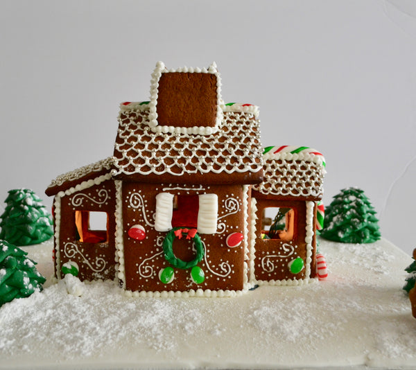 Gingerbread house with battery operated Christmas lights inside.  Decorate your home with this beautiful gingerbread house for Christmas and it is edible by Sugar Street Boutique Toronto. Gingerbread house toronto.