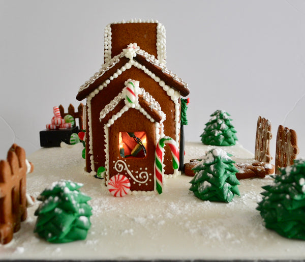 Gingerbread house with battery operated Christmas lights inside.  Decorate your home with this beautiful gingerbread house for Christmas and it is edible by Sugar Street Boutique Toronto. Gingerbread house toronto.